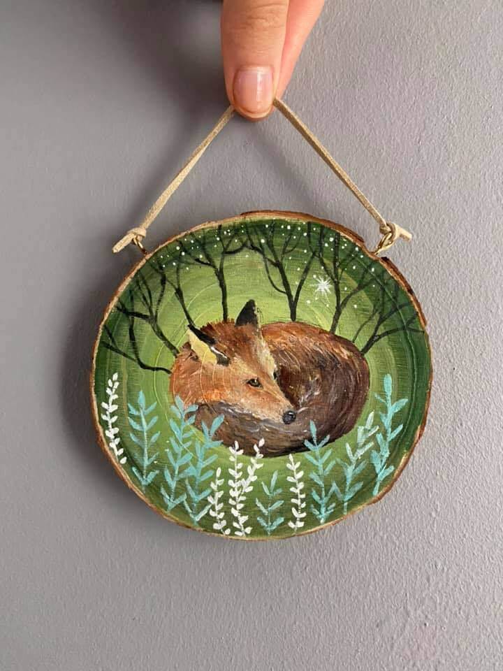 a wood decorations showing a fox curled up asleep in the woods