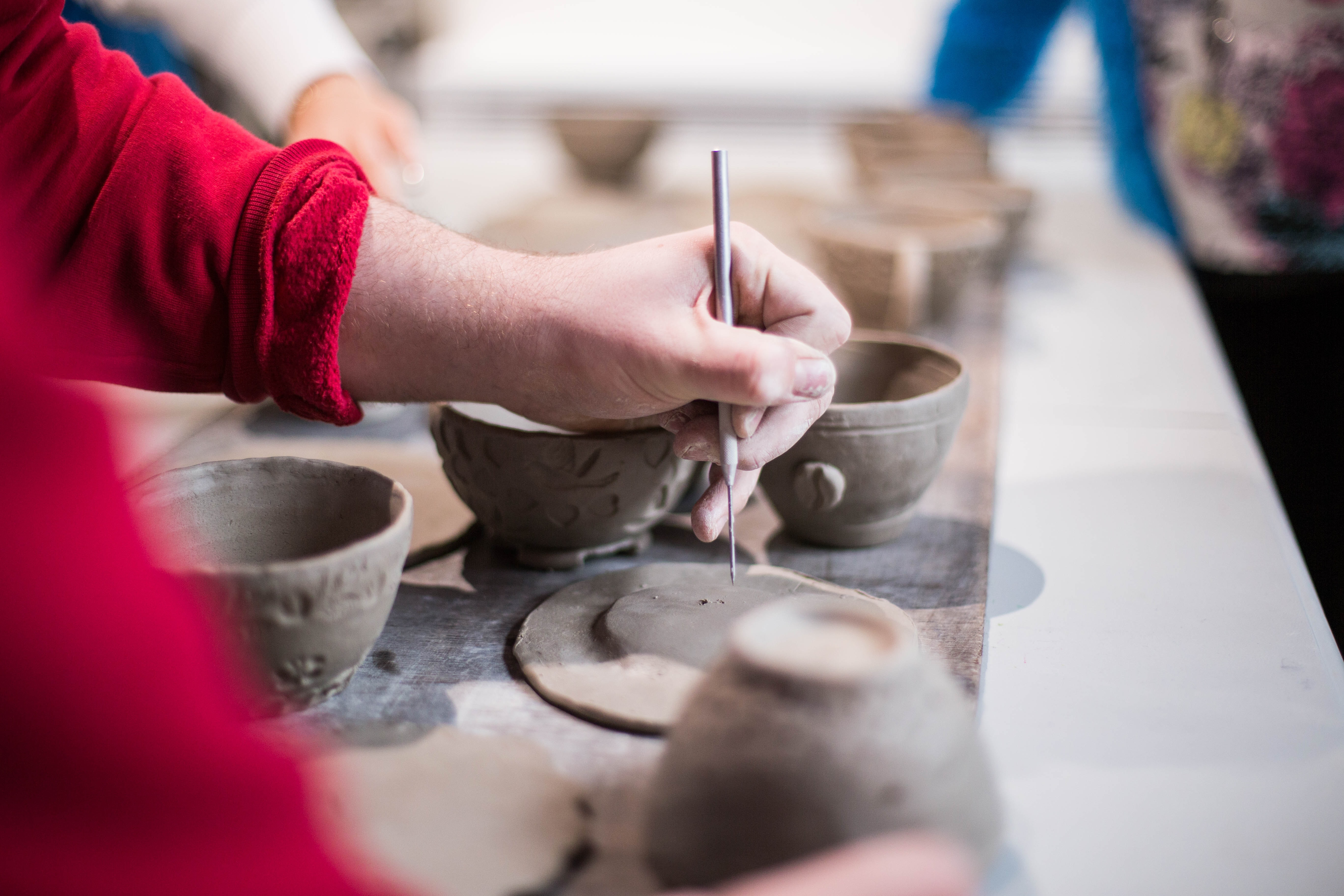 a person making indents into the clay