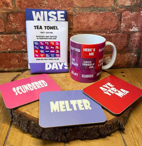 norn iron phrases on coasters, mugs, and tea towels in red and purple